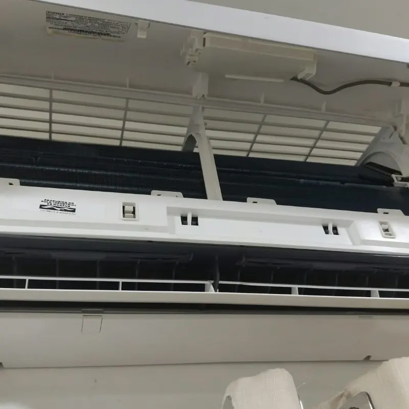 Evaporadora de ar-condicionado aberta, com a tampa frontal levantada para limpeza